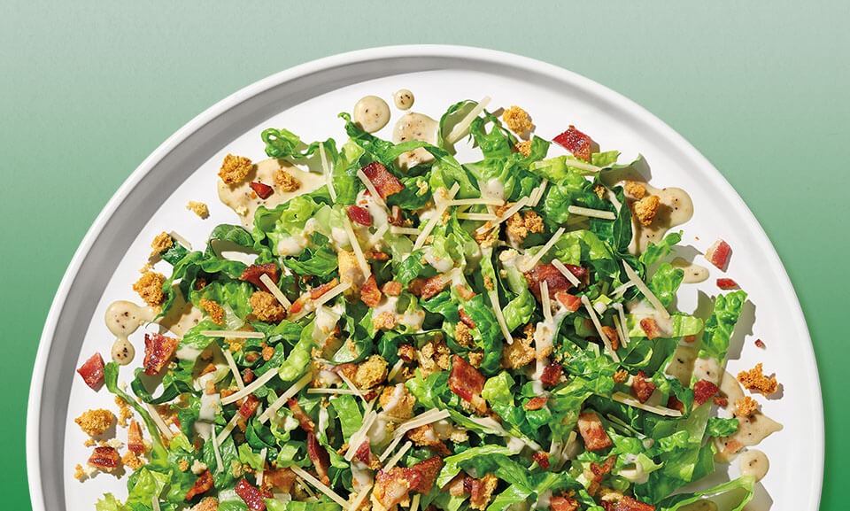 Bacon Caesar chopped salad kit featuring fresh greens, crispy bacon, and creamy dressing.