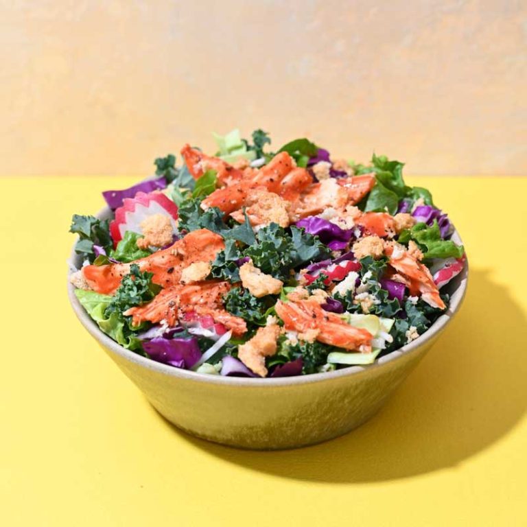Buffalo chicken dill pickle salad with fresh greens and vibrant toppings.
