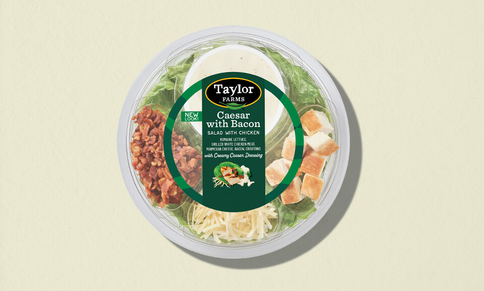 Single-serve Caesar Bacon Chicken bowl featuring fresh ingredients and vibrant packaging on a colorful background.