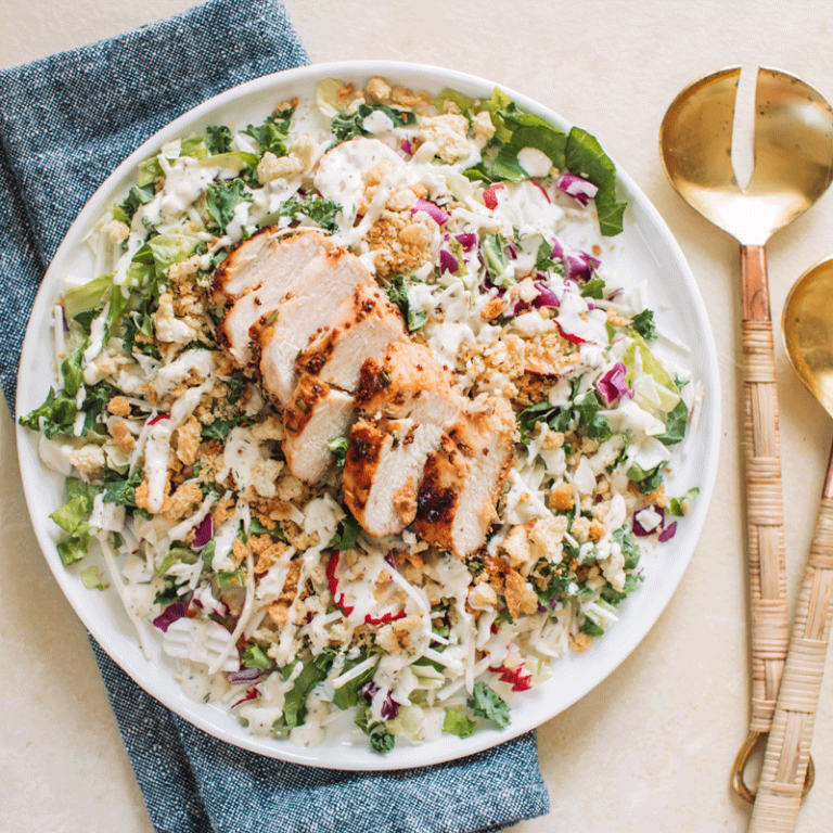 Dill pickle salad topped with honey mustard chicken, showcasing fresh ingredients and vibrant colors.