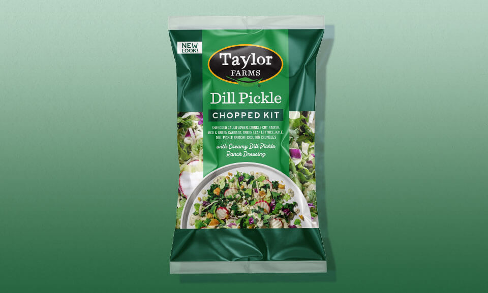 Dill pickle chopped salad kit featuring fresh greens and vibrant vegetables with a gradient background.