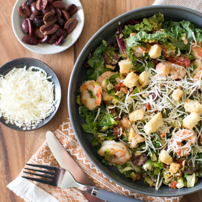 Fresh kale salad with colorful vegetables and dressing, perfect for healthy meal options.