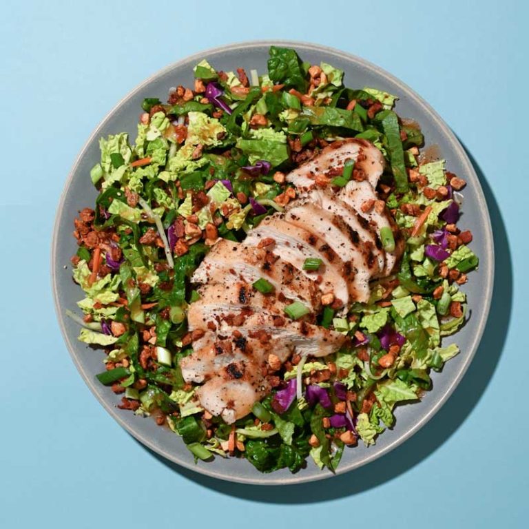 Maple bourbon grilled chicken salad topped with fresh greens, cherry tomatoes, and crunchy nuts.