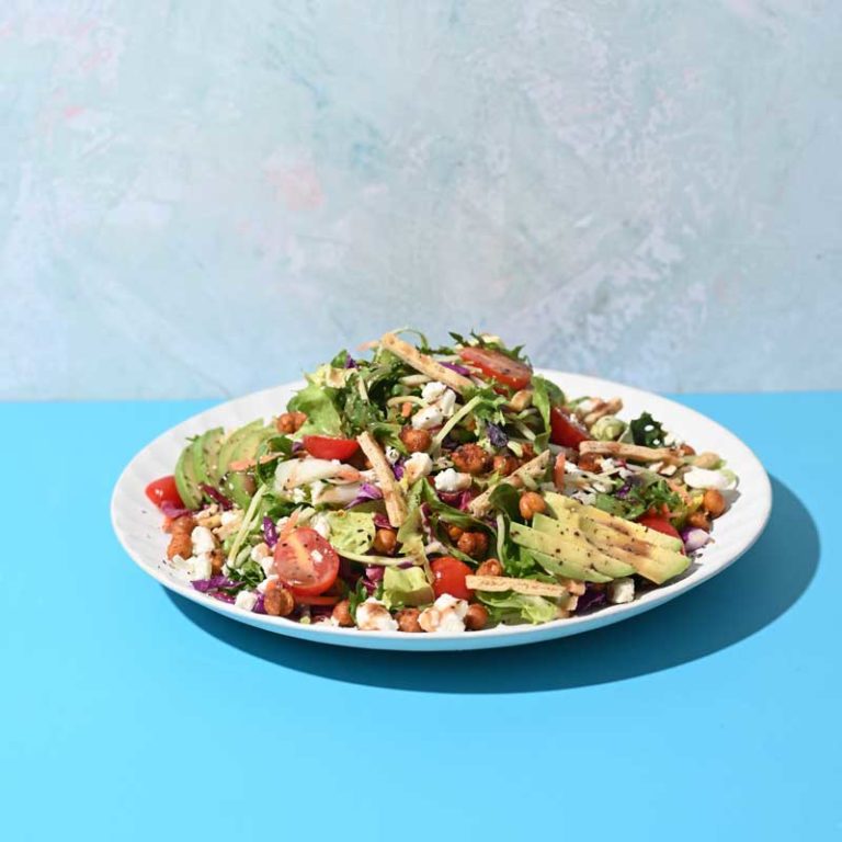 Vibrant Mediterranean roasted chickpea salad with fresh vegetables and herbs in a bowl.