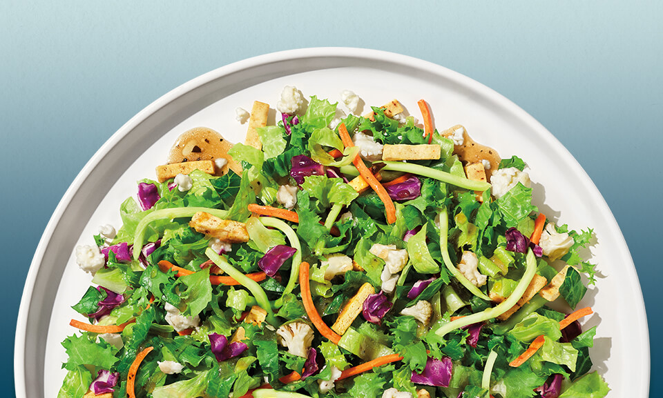Organic Mediterranean Crunch Chopped Kit featuring fresh greens, toppings, and dressing, perfect for a healthy meal option.