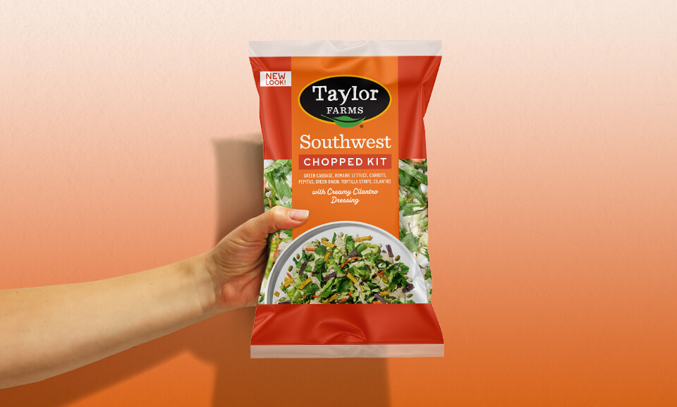 Hand holding a plate of Southwest Chopped Salad Kit, showcasing fresh ingredients and vibrant colors.