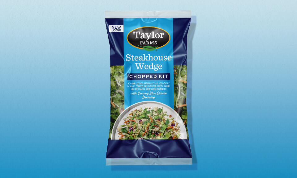 Steakhouse wedge chopped salad kit with fresh vegetables and dressing in colorful packaging.