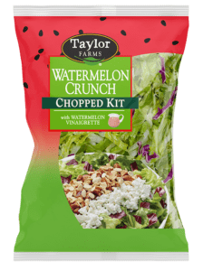 The Watermelon Crunch Chopped Salad Kit with romaine lettuce, radicchio, roasted almonds, roasted watermelon seeds, and feta cheese, which is topped with a watermelon lime vinaigrette.