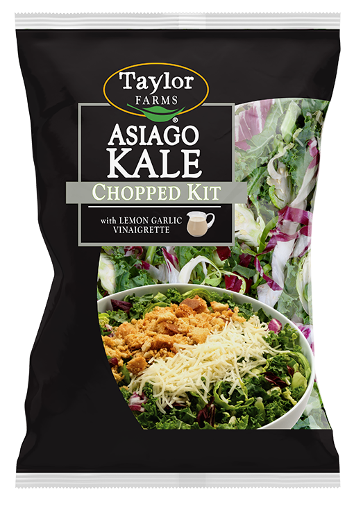 The Asiago Kale Chopped Salad kit package, showing chopped kale, shaved Brussels sprouts, and radicchio topped with Asiago cheese, Parmesan garlic crouton crumbles, and lemon garlic dressing.