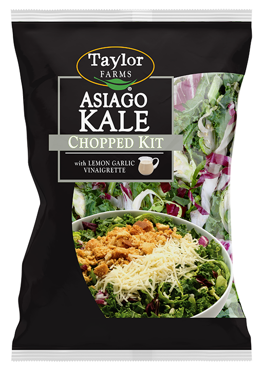 The Asiago Kale Chopped Salad kit package, showing chopped kale, shaved Brussels sprouts, and radicchio topped with Asiago cheese, Parmesan garlic crouton crumbles, and lemon garlic dressing.