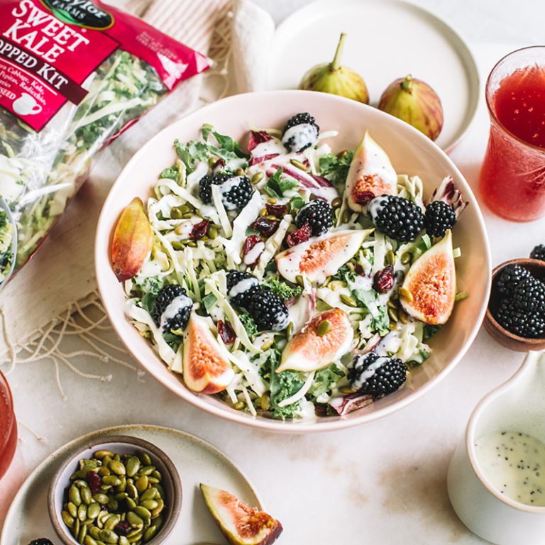 Fresh assorted salads with vibrant vegetables displayed in a colorful outdoor setting, showcasing Taylor Farms' offerings.