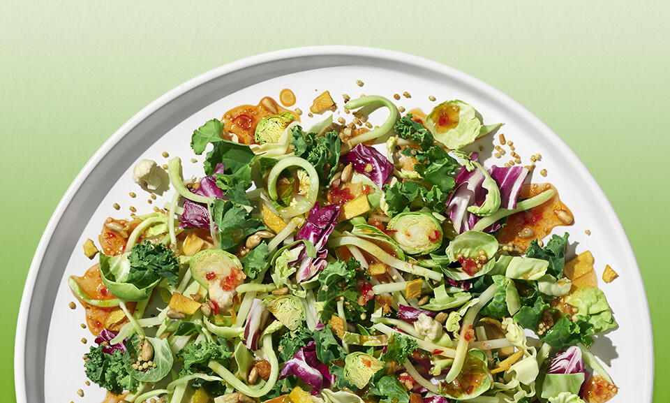 Thai Chili Mango Chopped Kit featuring vibrant salad ingredients, including mango, herbs, and crunchy vegetables.