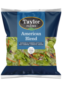 Fresh salad mix with a variety of greens, carrots, and colorful vegetables in a packaged container.