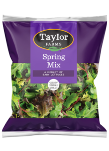 Fresh Taylor Farms mixed greens salad with vibrant vegetables in a clear bowl, perfect for healthy meals or side dishes.