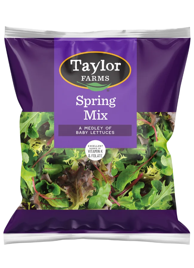 The Taylor Farms Spring Mix Salad in a purple bag, a medley of baby lettuces that is triple-washed and ready to eat.