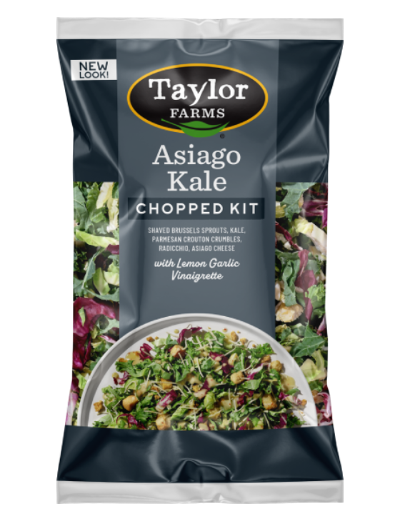 The Asiago Kale Chopped Salad kit package, showing chopped kale, shaved Brussels sprouts, and radicchio topped with Asiago cheese, Parmesan garlic crouton crumbles, and lemon garlic dressing.