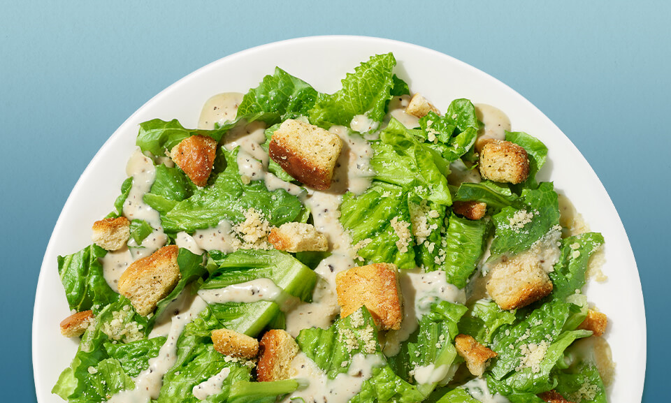 Everyday Caesar Salad Kit with fresh romaine lettuce, Parmesan cheese, croutons, and Caesar dressing.