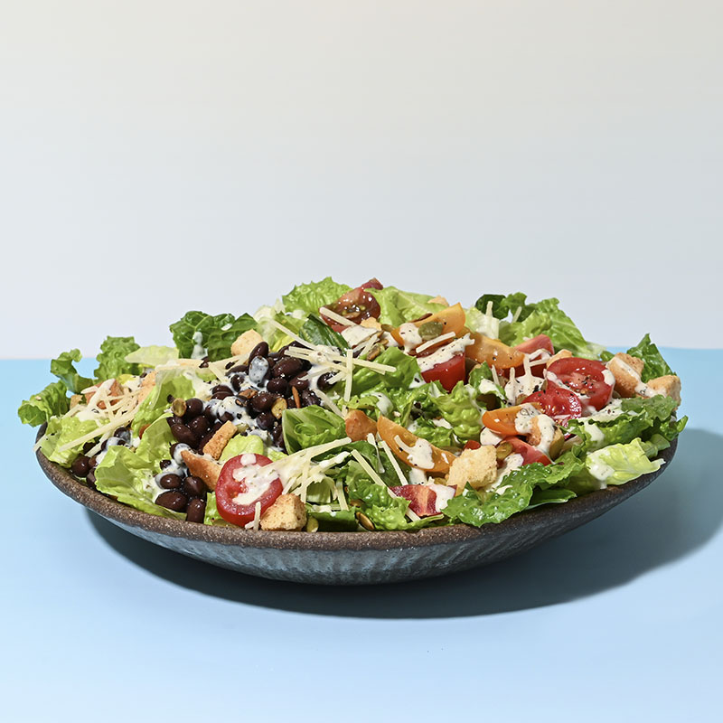 Mexican-style Caesar salad with fresh greens, parmesan, and zesty dressing in a bowl.