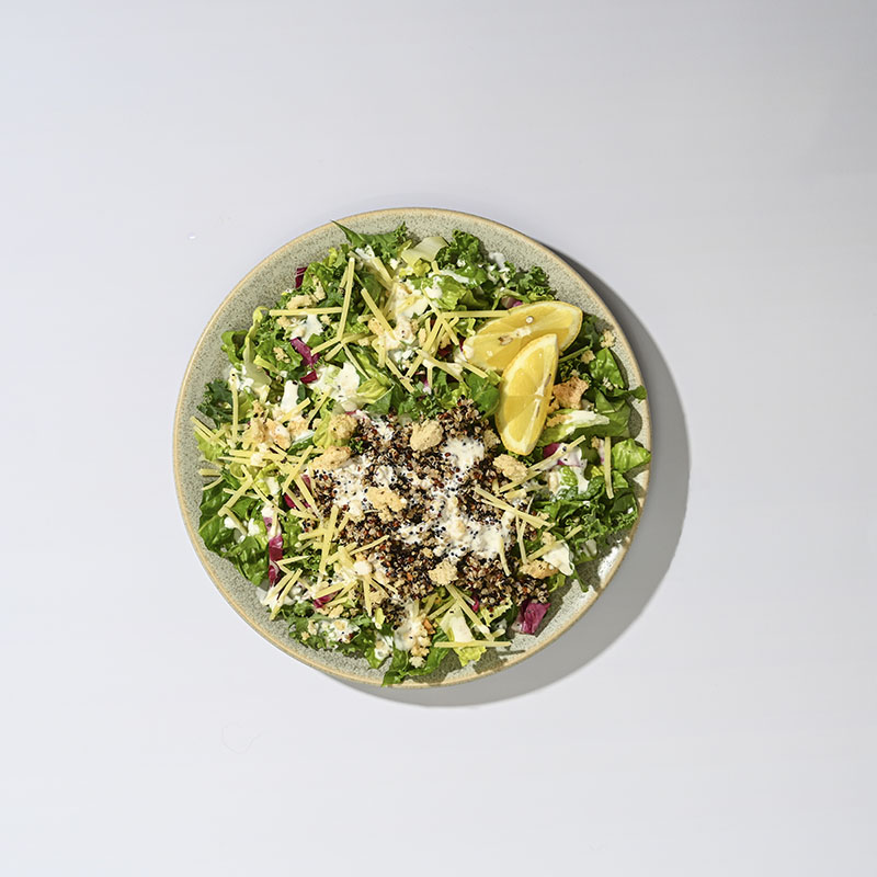 Organic kale caesar salad with creamy dressing, croutons, and parmesan cheese in a fresh, vibrant display.