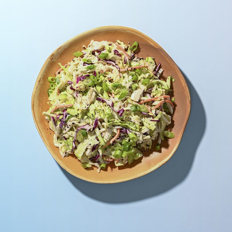 Colorful tri-color coleslaw mix featuring vibrant green cabbage, purple cabbage, and shredded carrots.