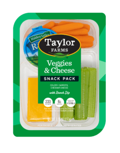 The Taylor Farms Veggies & Cheese Snack Pack package, showing celery stalks, baby carrots, cheddar cheese slices, and Hidden Valley Ranch dip.