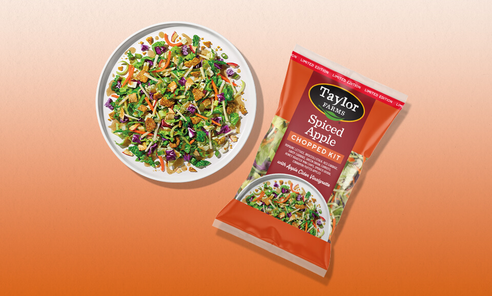 Spiced Apple Chopped Salad Kit with fresh ingredients displayed on a rustic wooden table.