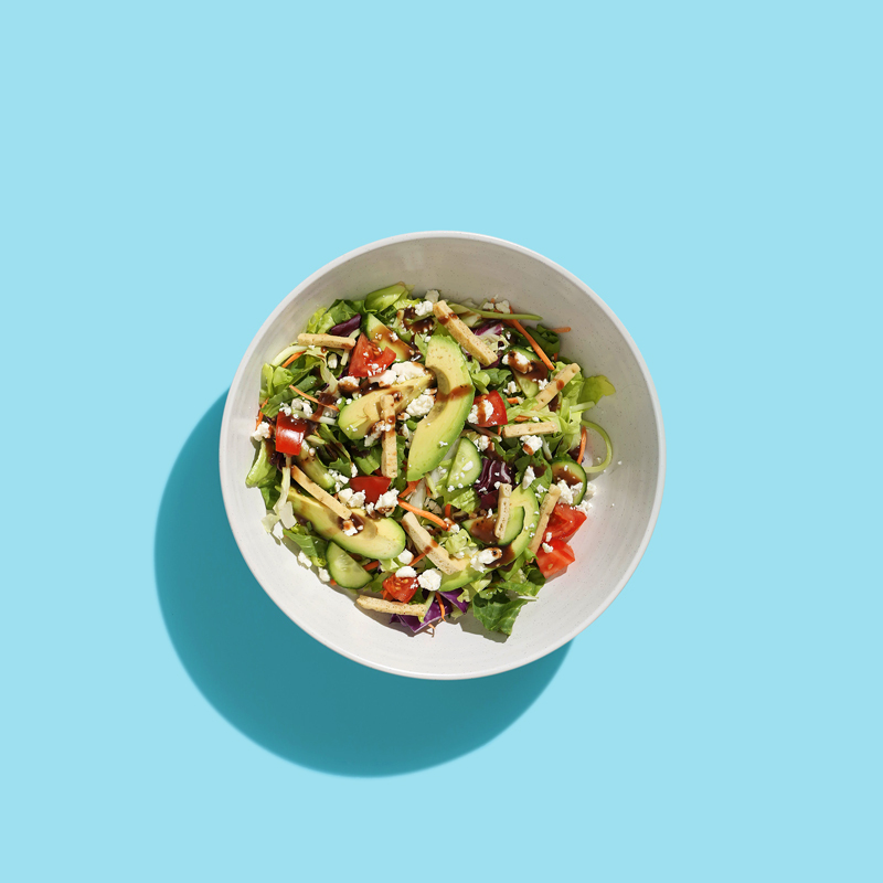 Mediterranean wellness salad with mixed greens, cherry tomatoes, cucumbers, olives, and feta cheese.
