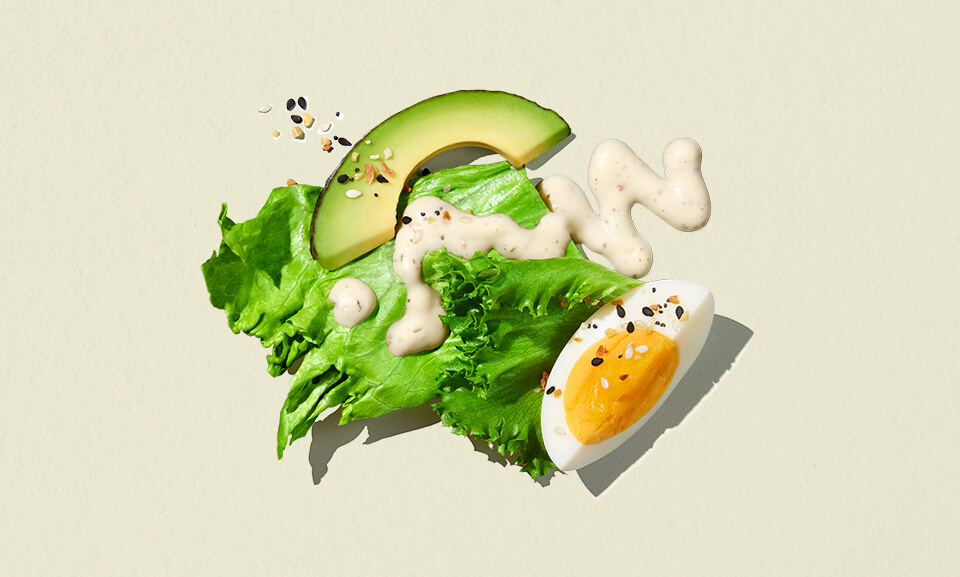 Single-serve avocado salad bowl with fresh greens, cherry tomatoes, and dressing, perfect for healthy meals on-the-go.