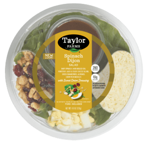Ready-to-eat Taylor Farms Spinach Dijon Salad in a bowl with greens, dressing, and toppings for a healthy meal option.