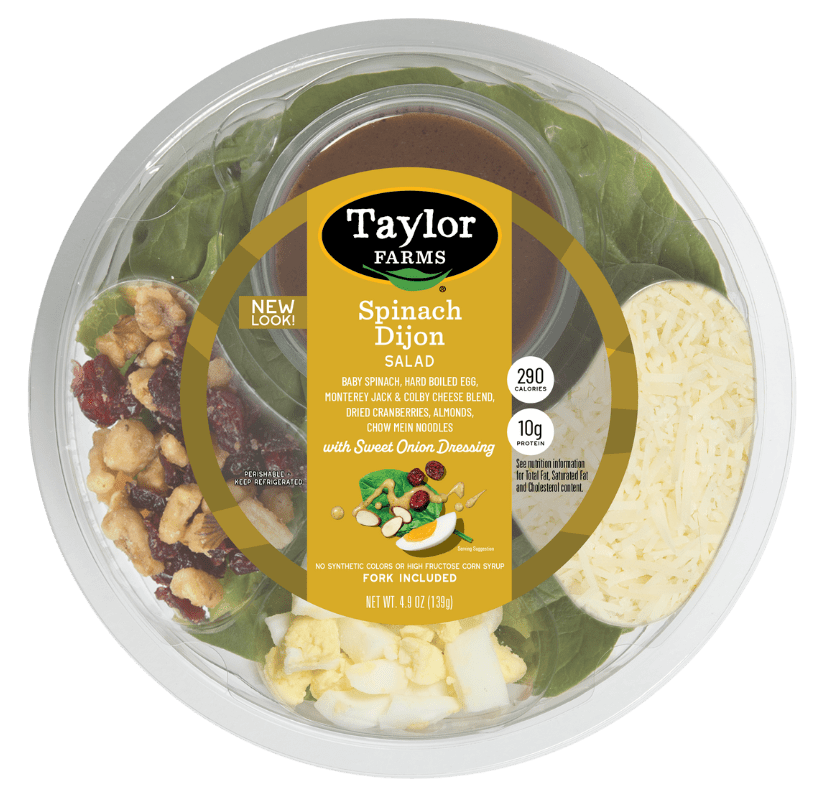 Ready-to-eat Taylor Farms Spinach Dijon Salad in a bowl with greens, dressing, and toppings for a healthy meal option.
