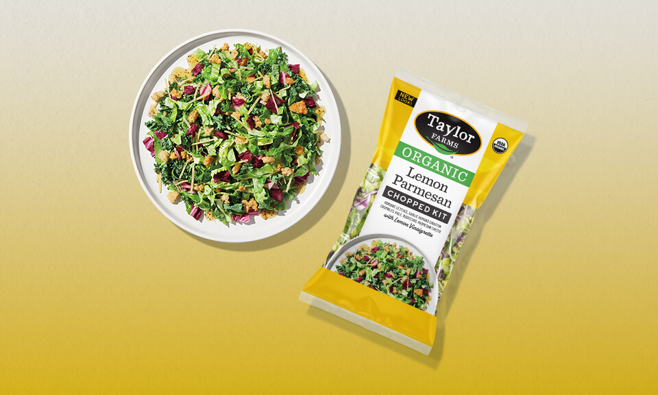 Organic lemon Parmesan salad on a plate, featuring fresh greens, lemon slices, and parmesan cheese shavings.