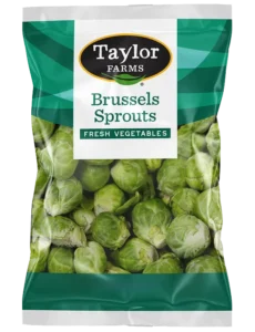 Fresh brussels sprouts arranged on a wooden surface, showcasing their vibrant green color and natural texture.