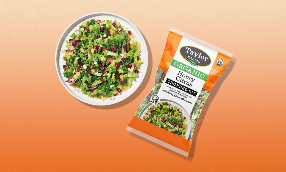 Organic Honey Citrus Chopped Salad Kit displayed on a white plate, featuring colorful vegetables and a citrus dressing.