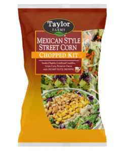 Taylor Farms Mexican Style Street Corn Chopped Salad Kit in a golden-colored pre-mixed package, showing the prepared salad with rows of corn, parmesan cheese, cornbread crumbles on a bed of green leaf lettuce with red cabbage and shredded carrots.