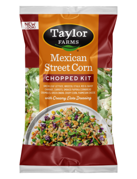 Taylor Farms Mexican Style Street Corn Chopped Salad Kit in a golden-colored pre-mixed package, showing the prepared salad with rows of corn, parmesan cheese, cornbread crumbles on a bed of green leaf lettuce with red cabbage and shredded carrots.