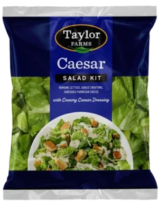 Fresh Caesar salad kit with romaine, croutons, parmesan cheese, and creamy dressing, perfect for a quick meal.