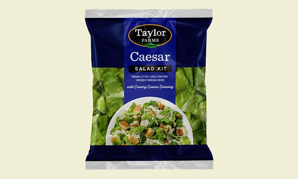 Fresh Caesar salad kit with romaine lettuce, croutons, and Caesar dressing by Taylor Farms.
