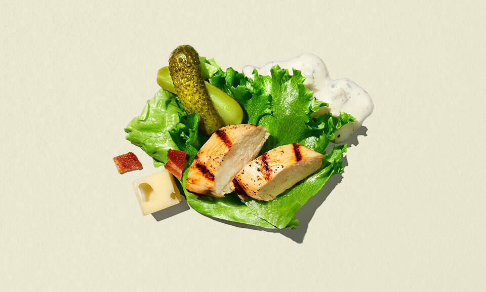 Dill pickle crunch salad in a single-serve bowl, featuring fresh greens, crunchy toppings, and a savory dressing.