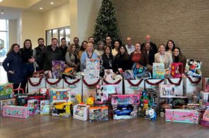 Group of people standing behind a line of boxes of toys