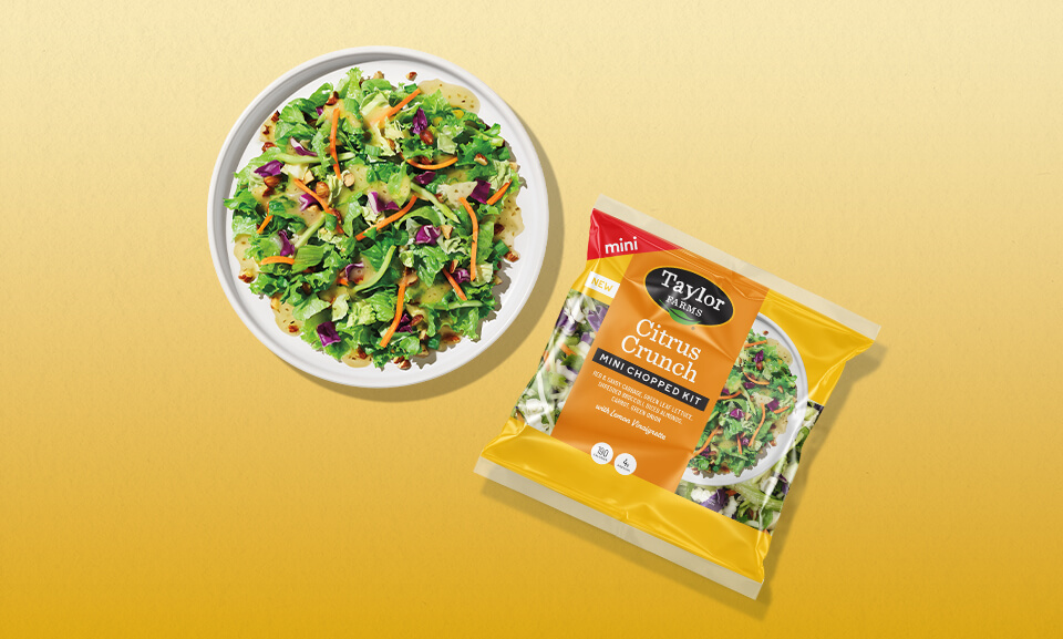 Citrus Crunch Mini Chopped Kit displayed on a plate with vibrant yellow packaging and fresh ingredients.