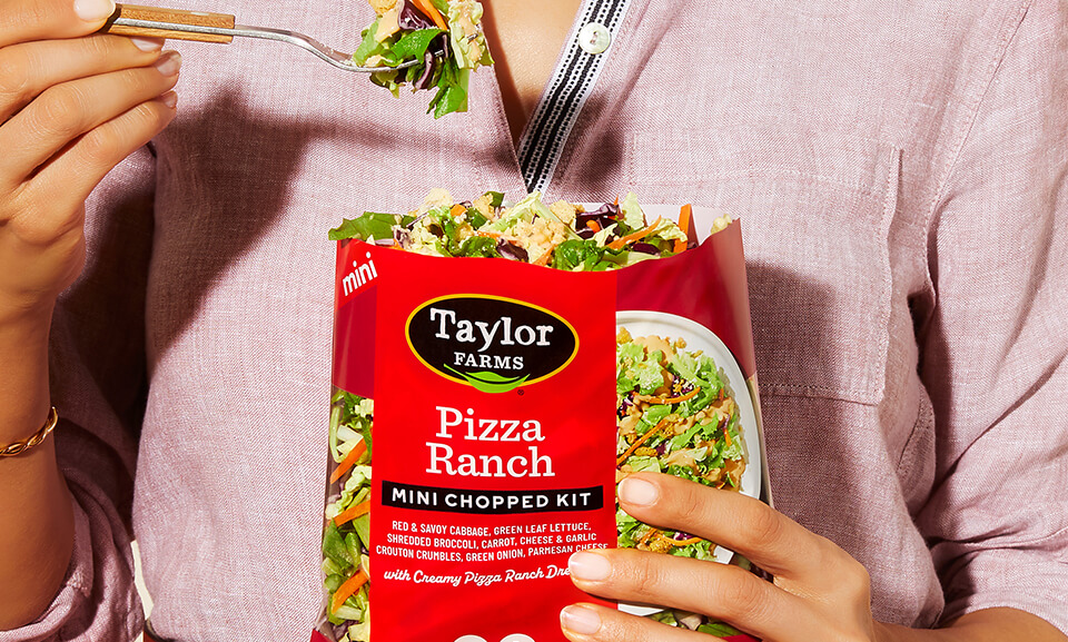 Mini Chopped Salad Kit from Taylor Farms featuring fresh ingredients ideal for pizza toppings, displayed in a vibrant lifestyle setting.