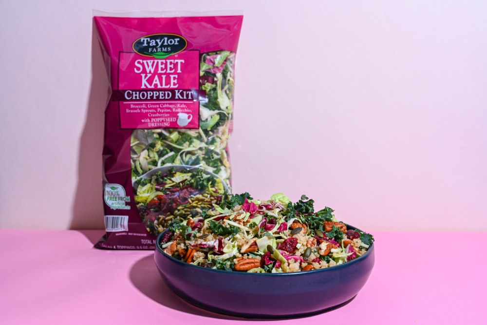 Taylor Farms Sweet Kale Quinoa Salad in a bowl with a bag in the background