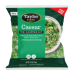 The Taylor Farms Caesar Mini Chopped Salad Kit package, showing romaine lettuce, cheese and garlic crouton crumbles, parmesan cheese, and a creamy caesar dressing.