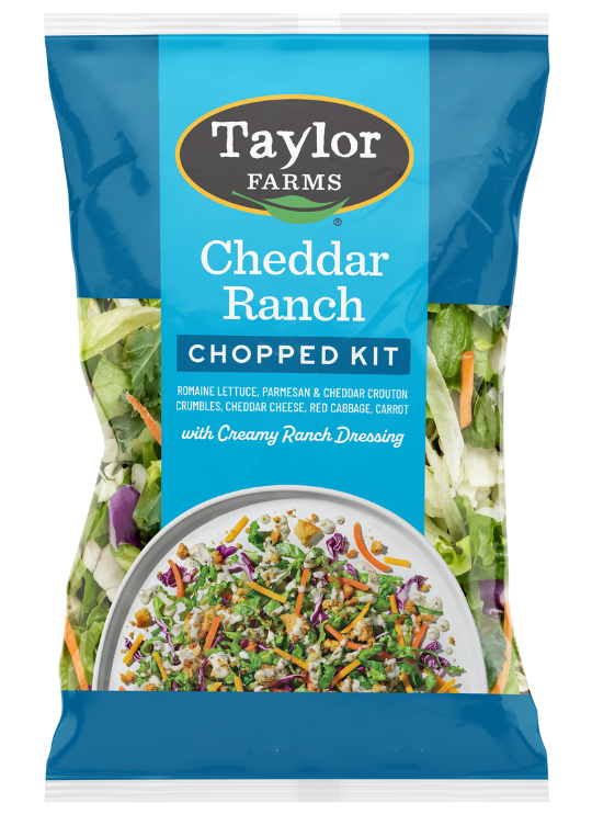 The Taylor Farms Cheddar Ranch Chopped Salad Kit package, showing chopped romaine, parmesan & cheddar-dusted crouton crumbles, red cabbage, carrot, cheddar cheese, and ranch dressing.