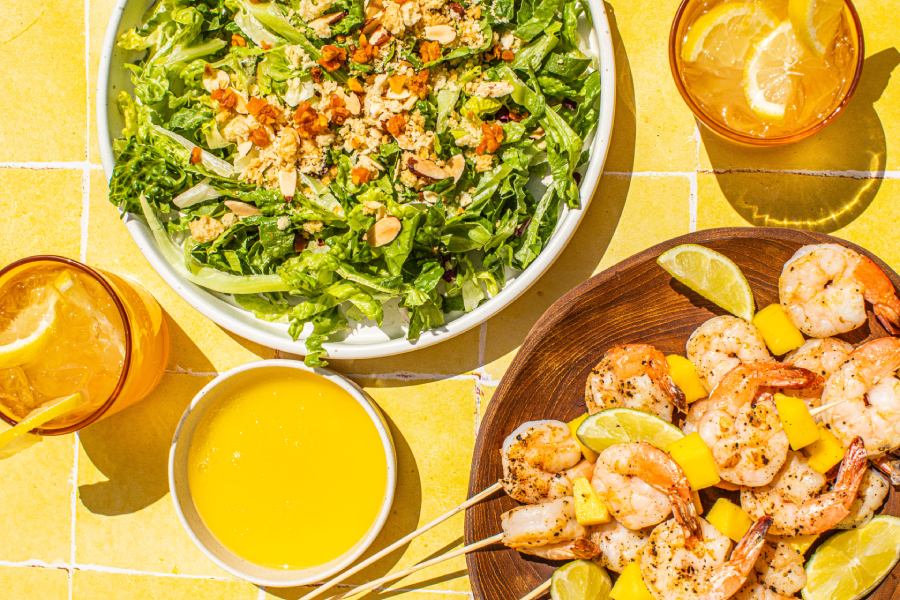 A bright bowl of Mango Lemonade Salad with Grilled Shrimp Skewers, featuring Taylor Farms’ Mango Lemonade Chopped Salad Kit.