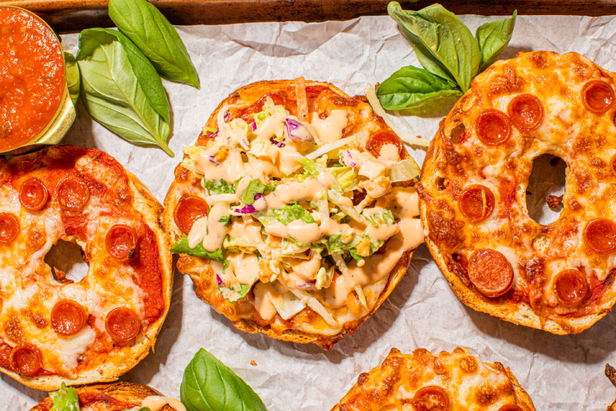 Pizza bagels topped with cheese and pepperonis, featuring Taylor Farms’ Pizza Ranch Mini Chopped Salad Kit.