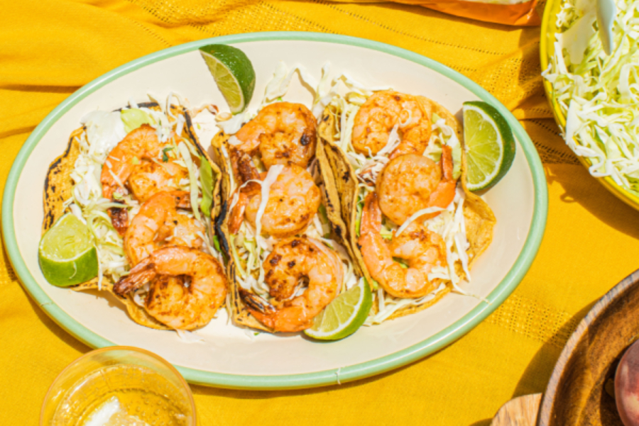 Taylor Farms Shrimp and Coleslaw Tacos on a plate with a yellow table cloth