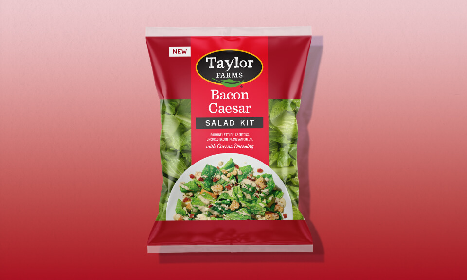 Bacon Caesar salad kit with fresh greens, crispy bacon, and creamy dressing in a vibrant packaging.