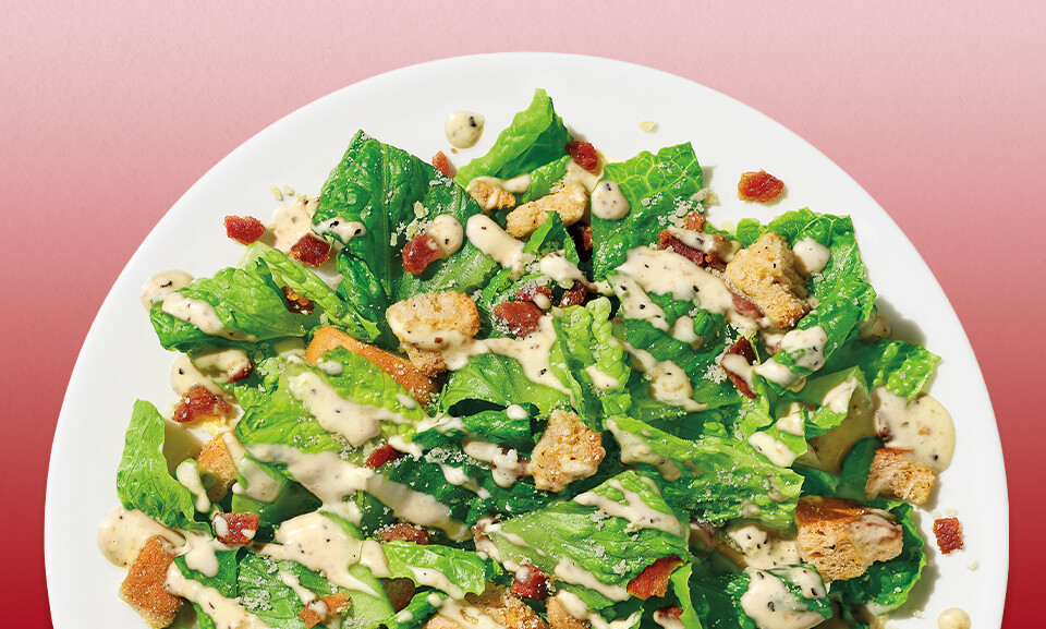 Bacon Caesar salad kit featuring fresh greens, crispy bacon, and creamy Caesar dressing.