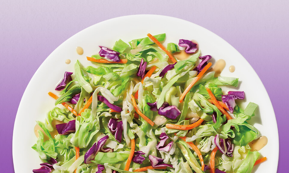 Fresh coleslaw salad kit featuring crunchy cabbage, carrots, and a flavorful dressing, perfect for quick meals.